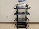 4 Sided Metal Display Rack With 16 Wire Basket Shelves And Headerboard / Wheels. Fixed Price $74.99.